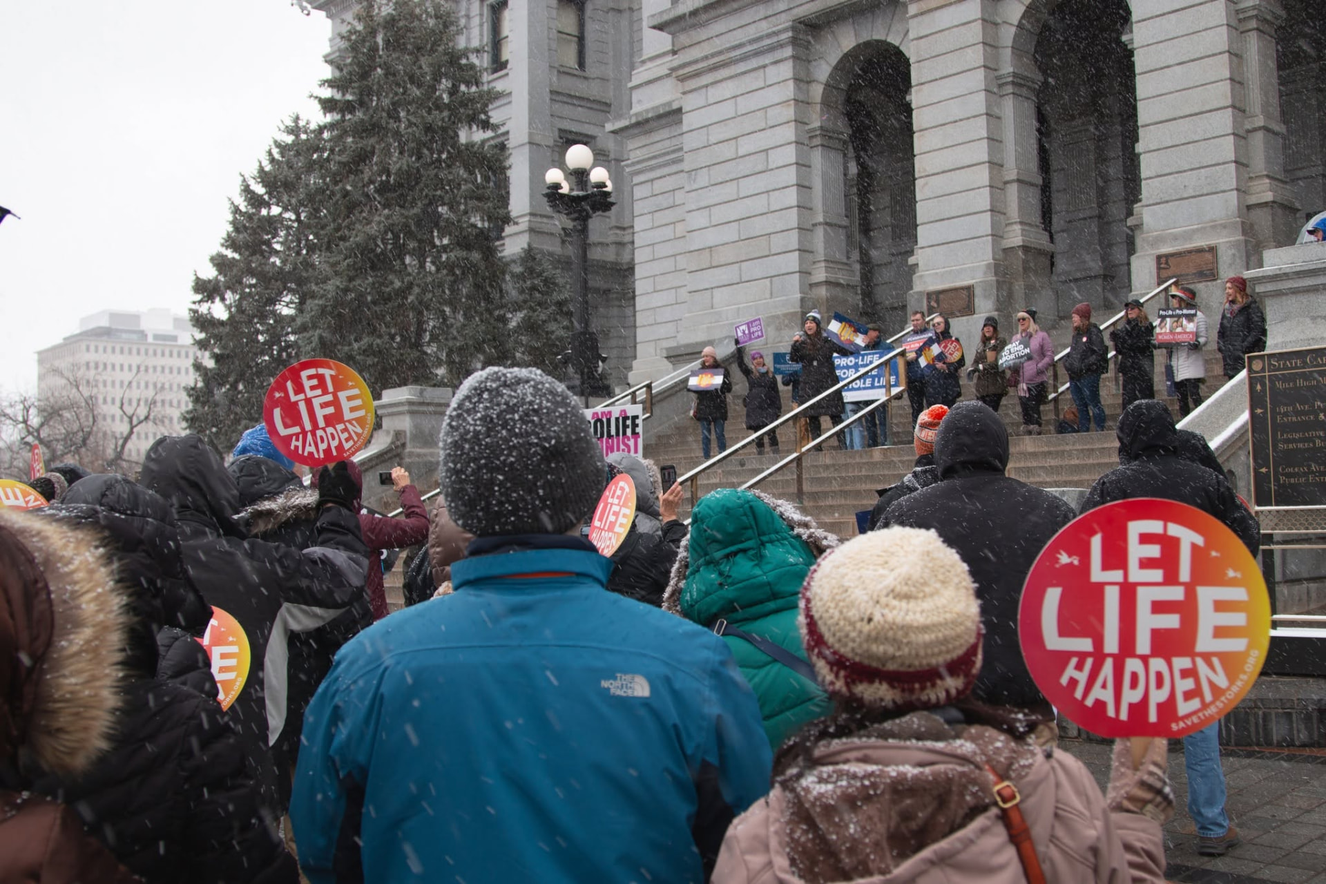 Supporters gathered with signs in the snow outside the Colorado State Capitol